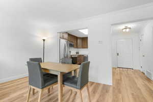 Dining room featuring light hardwood / wood-style flooring and ornamental molding