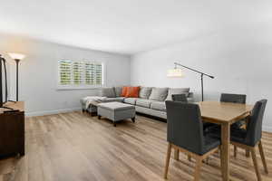 Living room with crown molding and light hardwood / wood-style floors