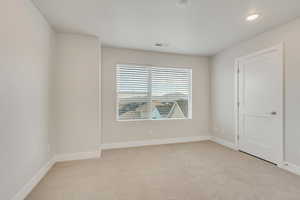 Empty room with light colored carpet