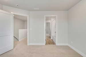 Unfurnished bedroom with light colored carpet