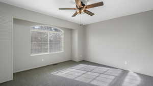 Spare room featuring carpet and ceiling fan