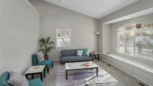 Sitting room with light colored carpet, plenty of natural light, and ornamental molding