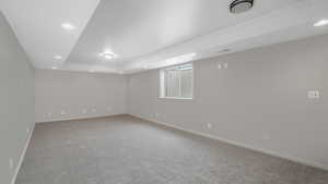 Carpeted empty room with a raised ceiling