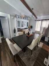 Dining room featuring vaulted ceiling with beams and dark wood-type flooring