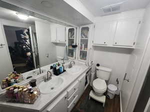 Bathroom with hardwood / wood-style flooring, vanity, and toilet