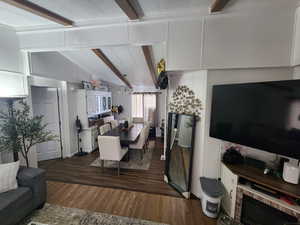 Dining space with lofted ceiling with beams and dark wood-type flooring