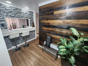 Bar featuring wood walls and wood-type flooring