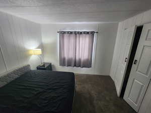 Carpeted bedroom with wooden walls