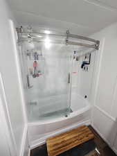 Bathroom featuring shower / bathing tub combination, a textured ceiling, and hardwood / wood-style flooring