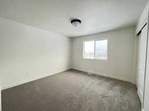 Unfurnished bedroom featuring carpet flooring and a closet