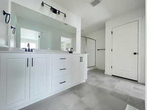 Bathroom with tile patterned floors, vanity, and a shower with shower door