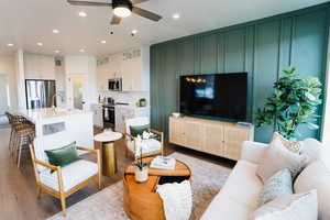 Living room with ceiling fan, sink, and light hardwood / wood-style flooring