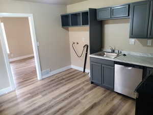 Kitchen with dishwasher, stove, light wood-type flooring, and sink