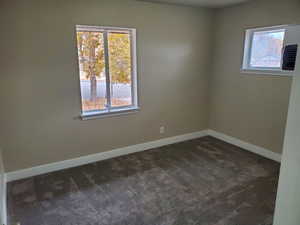 Unfurnished room with dark colored carpet