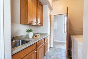 Laundry room including sink and storage area around the corner