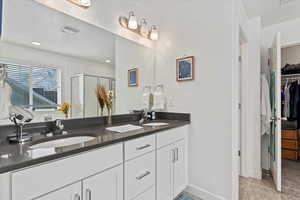 Bathroom with tile patterned floors, vanity, and walk in shower