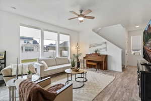 Living room with ceiling fan and light hardwood / wood-style flooring