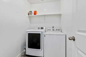 Laundry area featuring washing machine and dryer and shelf