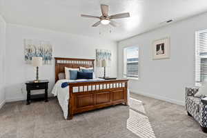 Bedroom with ceiling fan and light colored carpet