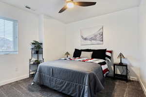 Bedroom with dark colored carpet and ceiling fan