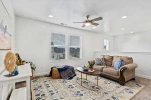 Carpeted living room with ceiling fan