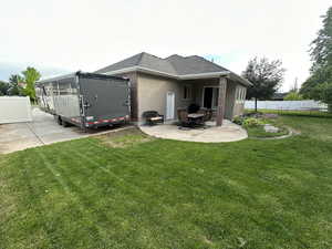 Back of property with a yard and a patio area