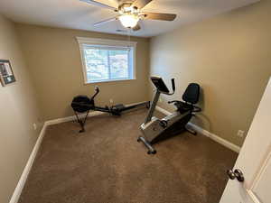 Exercise room with ceiling fan and carpet floors