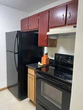 Kitchen featuring black appliances and light tile patterned flooring