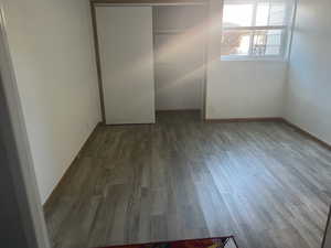 Unfurnished bedroom featuring dark wood-type flooring