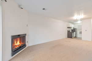 Unfurnished living room featuring light carpet