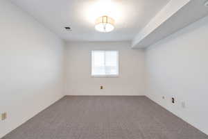 Empty room with carpet and a textured ceiling