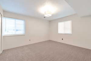 Carpeted empty room with a textured ceiling