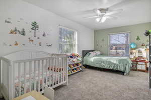 Bedroom featuring a textured ceiling, carpet floors, and a ceiling fan