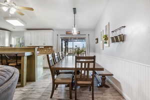 Dining room with light tile wood-style flooring, ceiling fan, and lofted ceiling