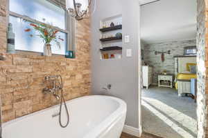 Bathroom featuring a bathtub and a chandelier