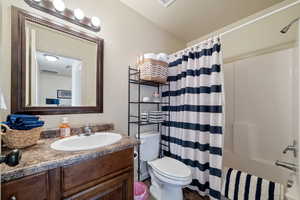 Full bathroom featuring vanity, shower / bath combination with curtain, and toilet