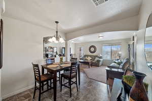 Dining space featuring a chandelier and a textured ceiling