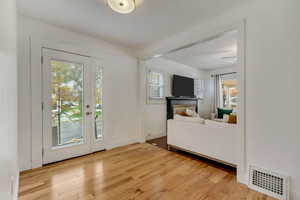 Foyer entrance featuring a fireplace, light hardwood / wood-style floors, and plenty of natural light