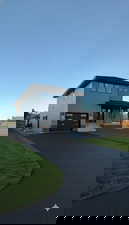 View of front of home with a front lawn, asphalt driveway, and an attached garage