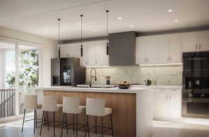 Kitchen with white cabinets, stainless steel fridge, light hardwood / wood-style flooring, and a kitchen island with sink