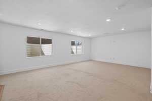 Carpeted empty room with a textured ceiling