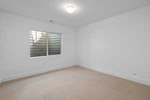 Spare room featuring carpet floors and a textured ceiling