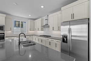 Kitchen with tasteful backsplash, sink, wall chimney exhaust hood, and stainless steel appliances