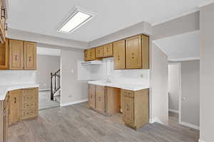 Kitchen featuring backsplash, sink, and light wood-type flooring