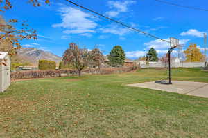 View of yard featuring a mountain view and basketball hoop