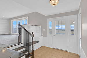 Entryway with a textured ceiling and light tile patterned flooring