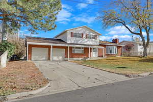 Front facade featuring a garage and a front lawn