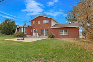 Back of property featuring a lawn and a patio