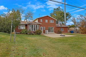 Rear view of property featuring a patio and a lawn