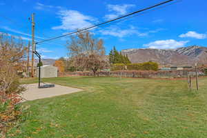 View of yard with a patio area, a mountain view, and a shed